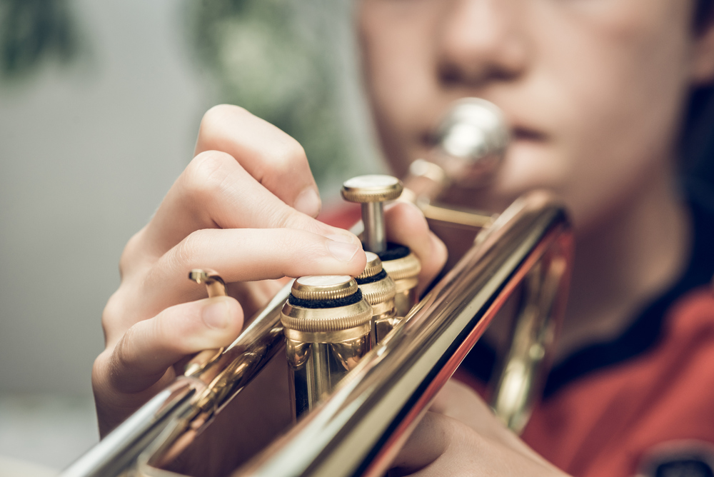 Student Playing Trumpet , close up of hands on trumpet. 
