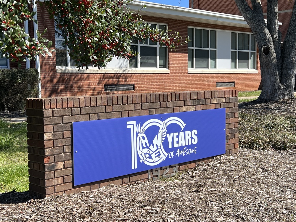 Photo of front of Alexander Wilson Elementary showing 100 year logo sign.  