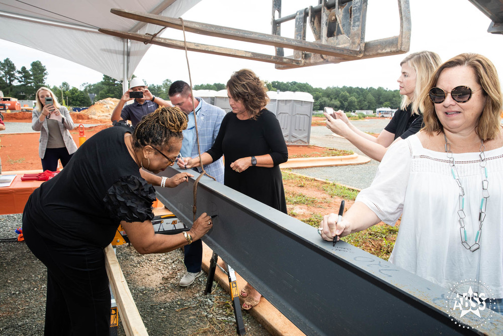 ABSS Board members signing final beam at new high school's topping out ceremony 