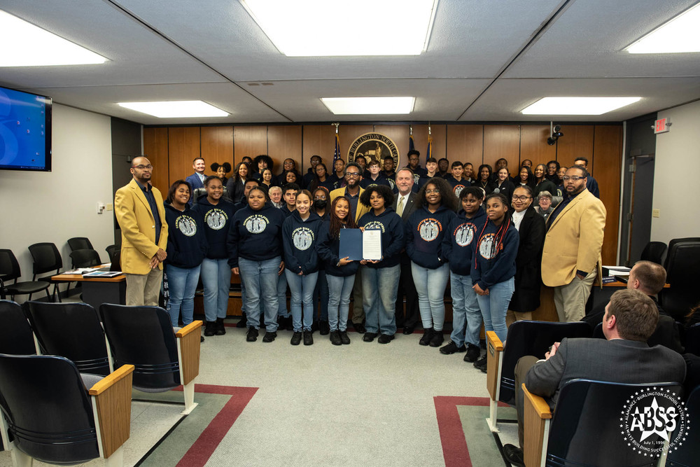 Group photo of band with Burlington City Council. Students holding proclamation 
