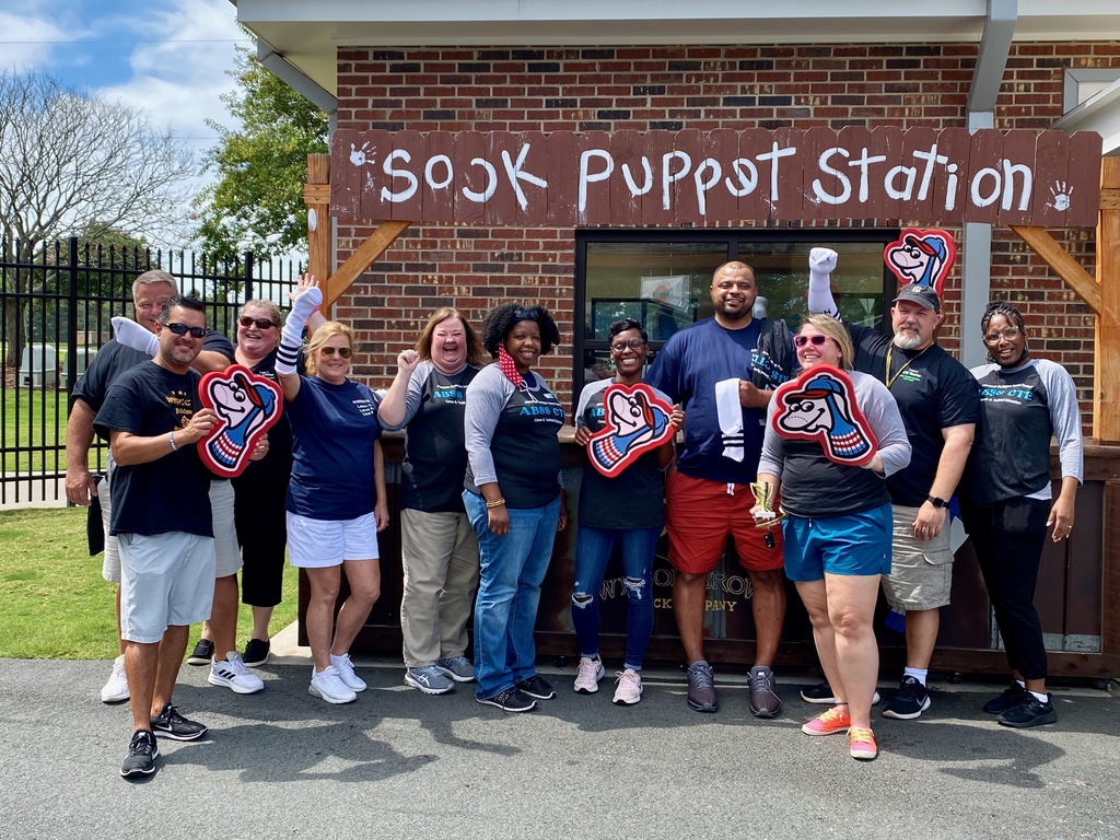 Photo of CTE Staff cheering in front of Sock Puppet Station