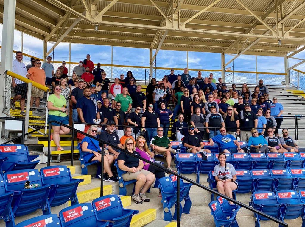 Group photo of CTE staff sitting in the stands at the Sock Puppets stadium
