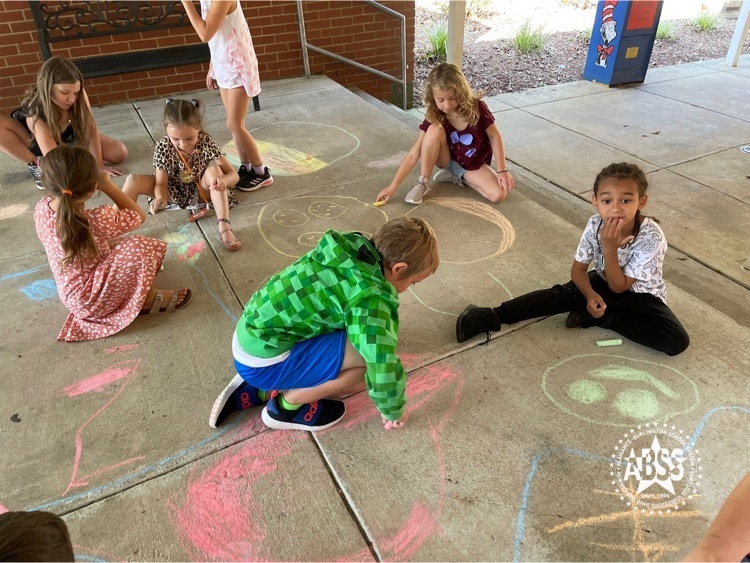 International dot day celebration. Children creating chalk art on the sidewalk at Sylvan Elementary