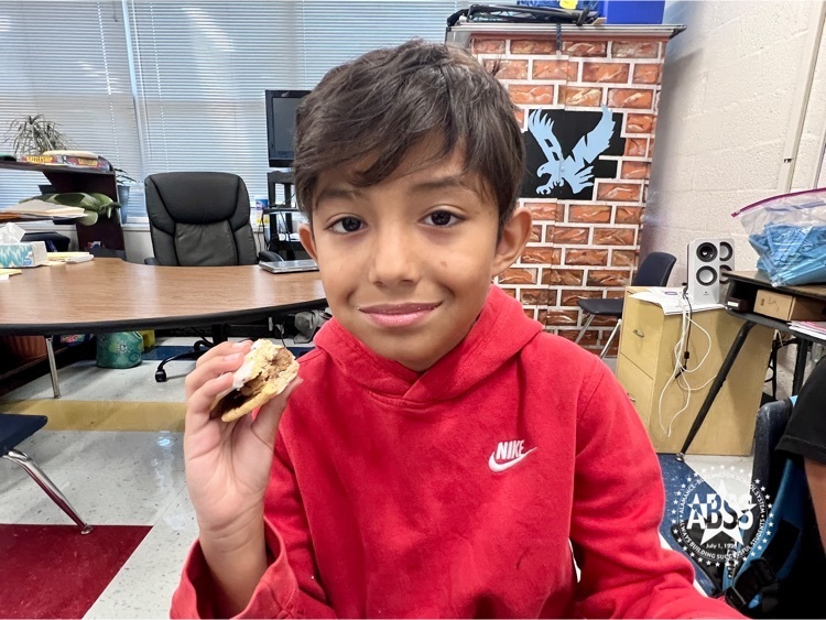 student holding peanut butter sandwich as part of class exercise