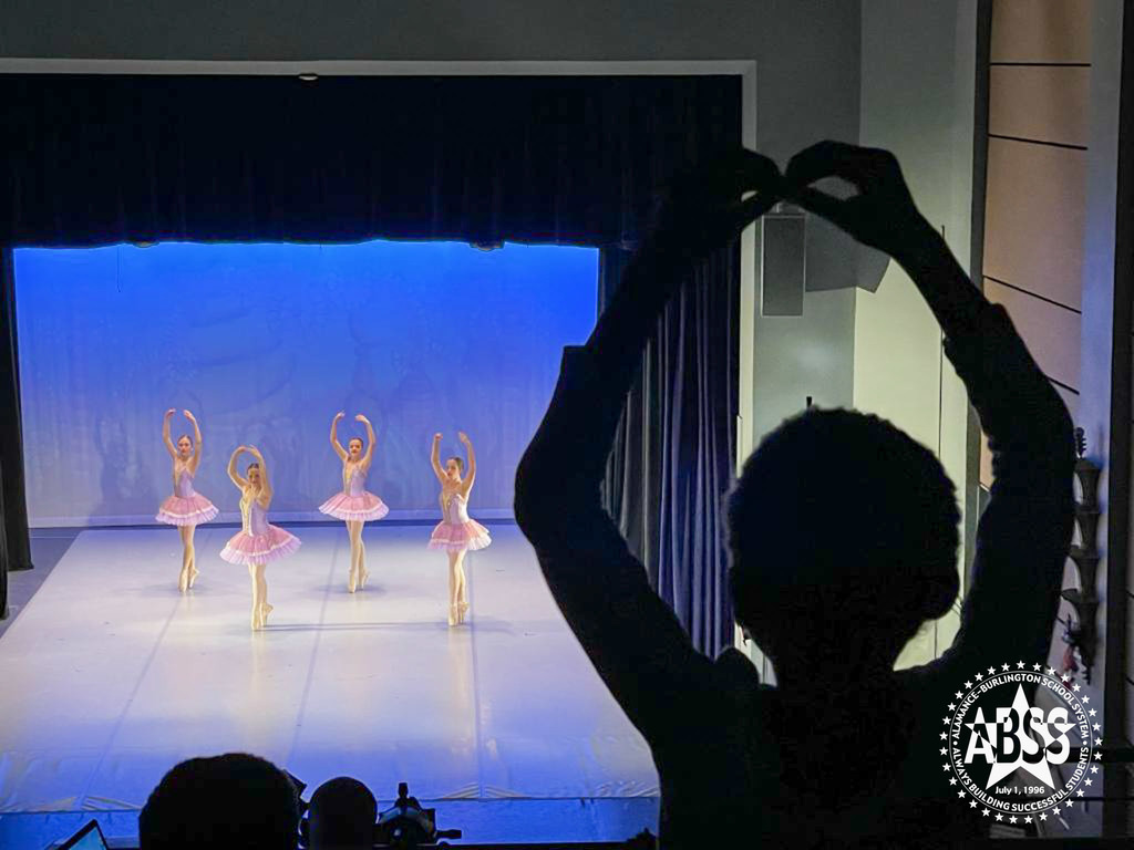 A student imitates the motions of the ballerinas on stage from the balcony
