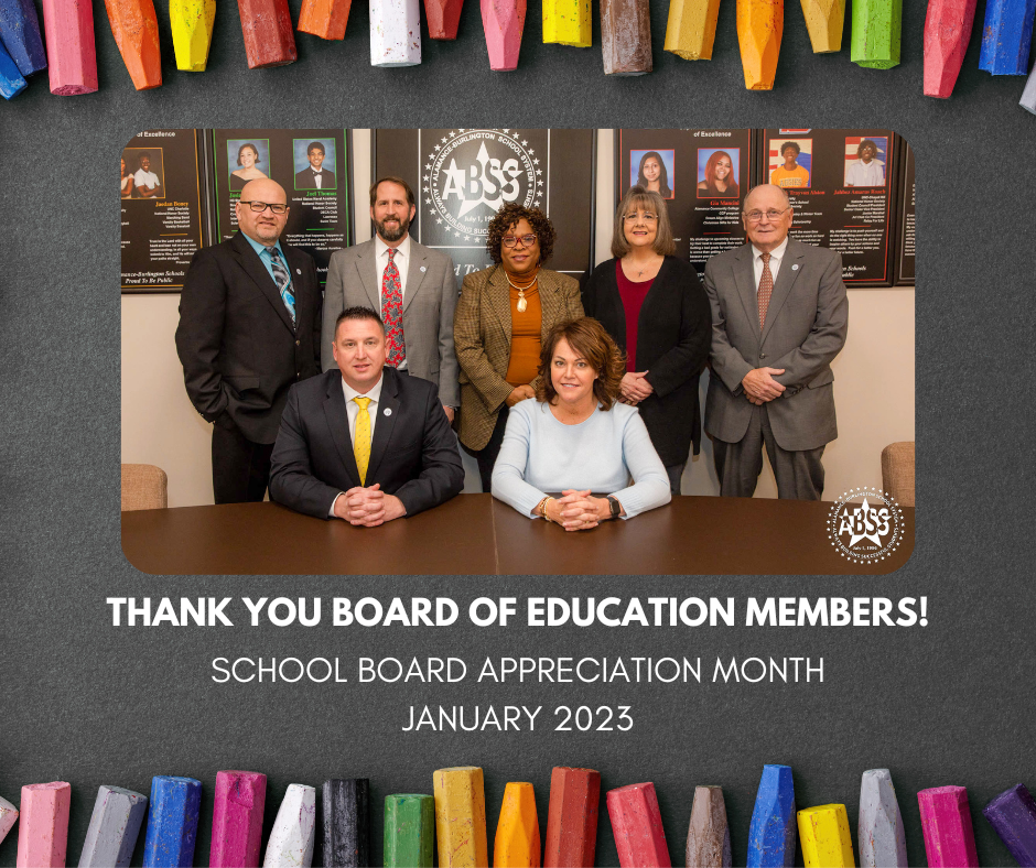 A photograph of all current school board members standing in the auditorium.  There is a black chalk background and worn crayons as a border.  Below the photograph is text "Thank you Board of Education members1" School Board Appreciation Month.  January 2023.