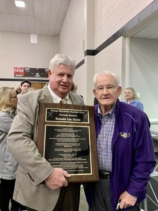 ormer Turrentine teacher, coach and Athletic Director Coach Ron Davis standing beside a member of the Coach George Whitfield’s Baseball Clinic Hall of Fame committee holding a plaque with his name and accomplishments