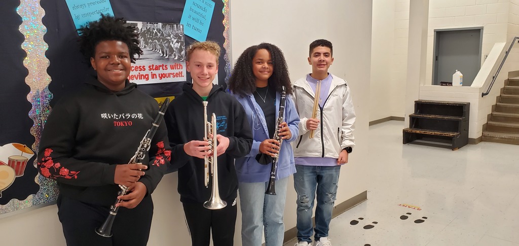 Four of our Woodlawn Band members standing in the hallway holding instruments