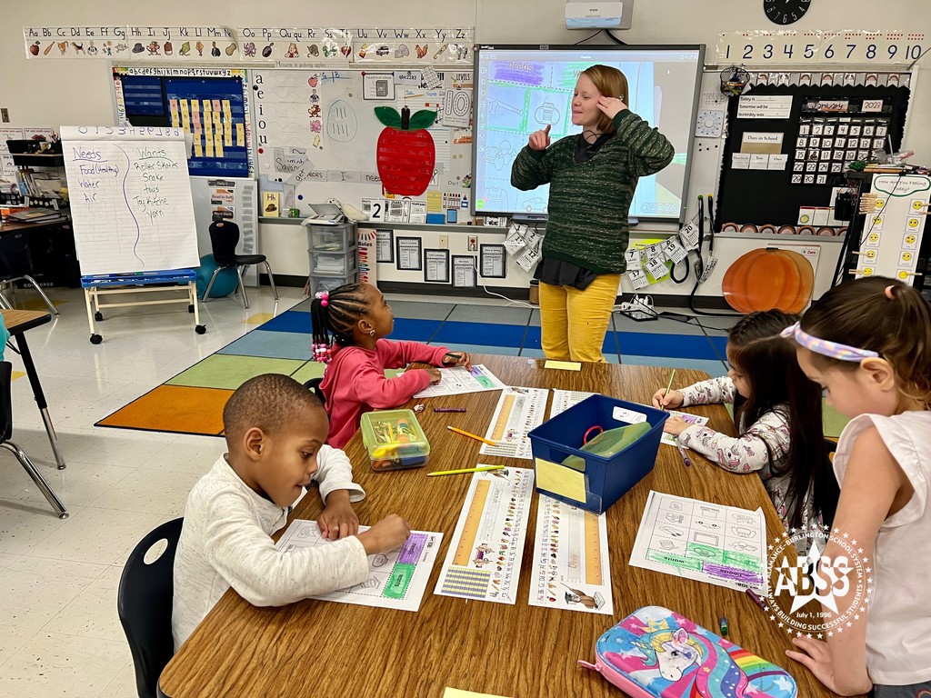 Kirstin Blalock-Shaw from Highland Elementary stands in front of four kindergarten students as part of a lesson about Wants and Needs