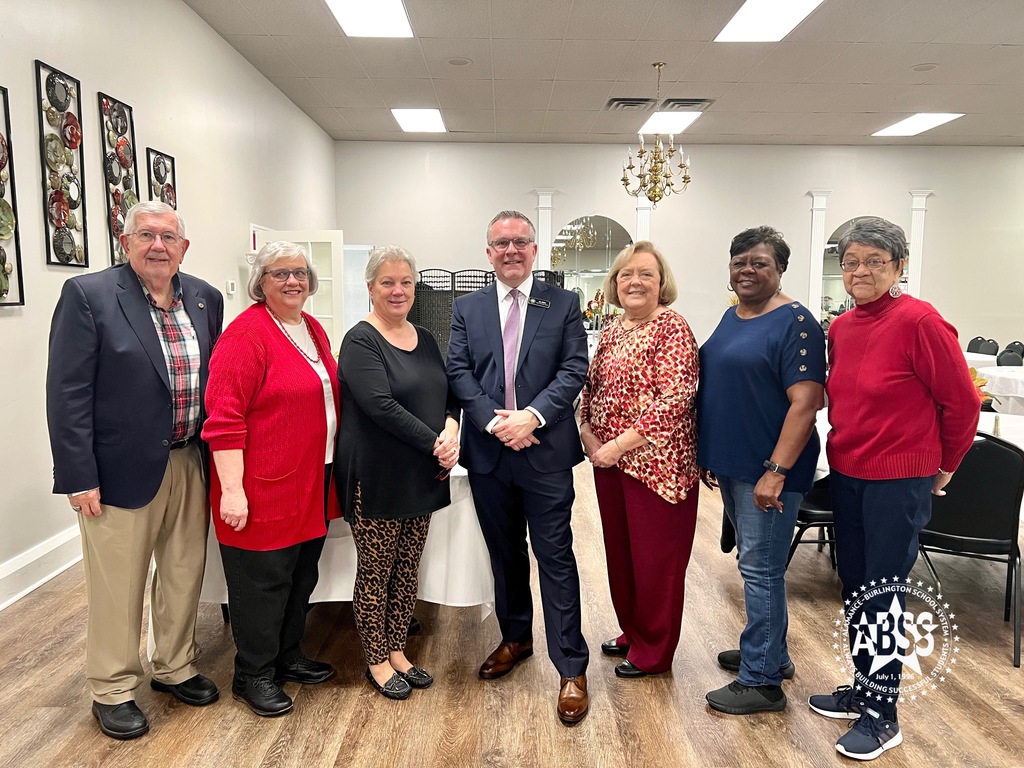 Public Information Officer Les Atkins standing with six retired educators during the orth Carolina Retired School Personnel Alamance Burlington Chapter Meeting