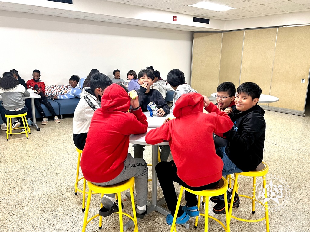 Small groups of students sitting around some of the new cafeteria furniture at Broadview Middle.  The table in the foreground is round with yellow stools.