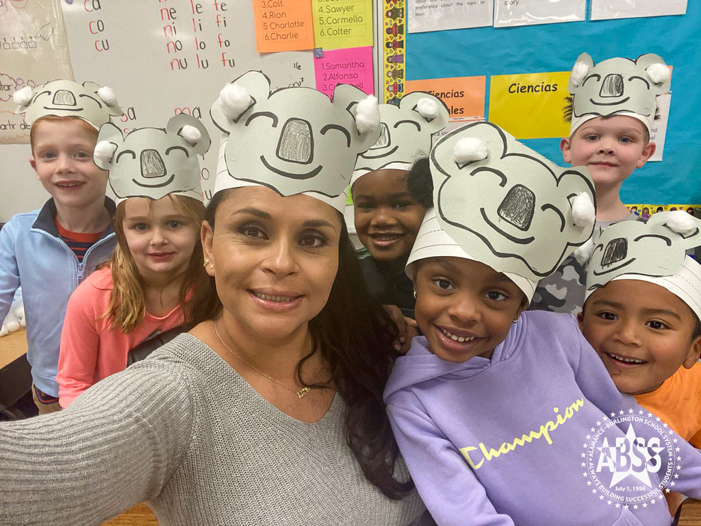 Kindergarten teacher Aceneth Cruz poses in a selfie photograph with her kindergarten students wearing koala craft headbands