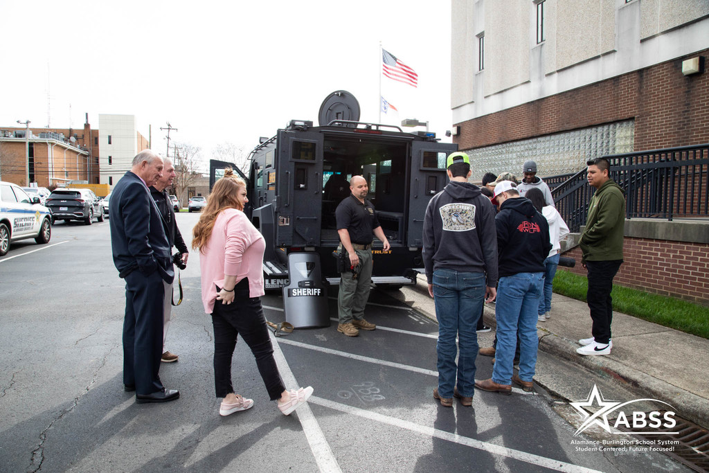 Graham High School students observe gearand procedures behind a SWAT vehicle outside