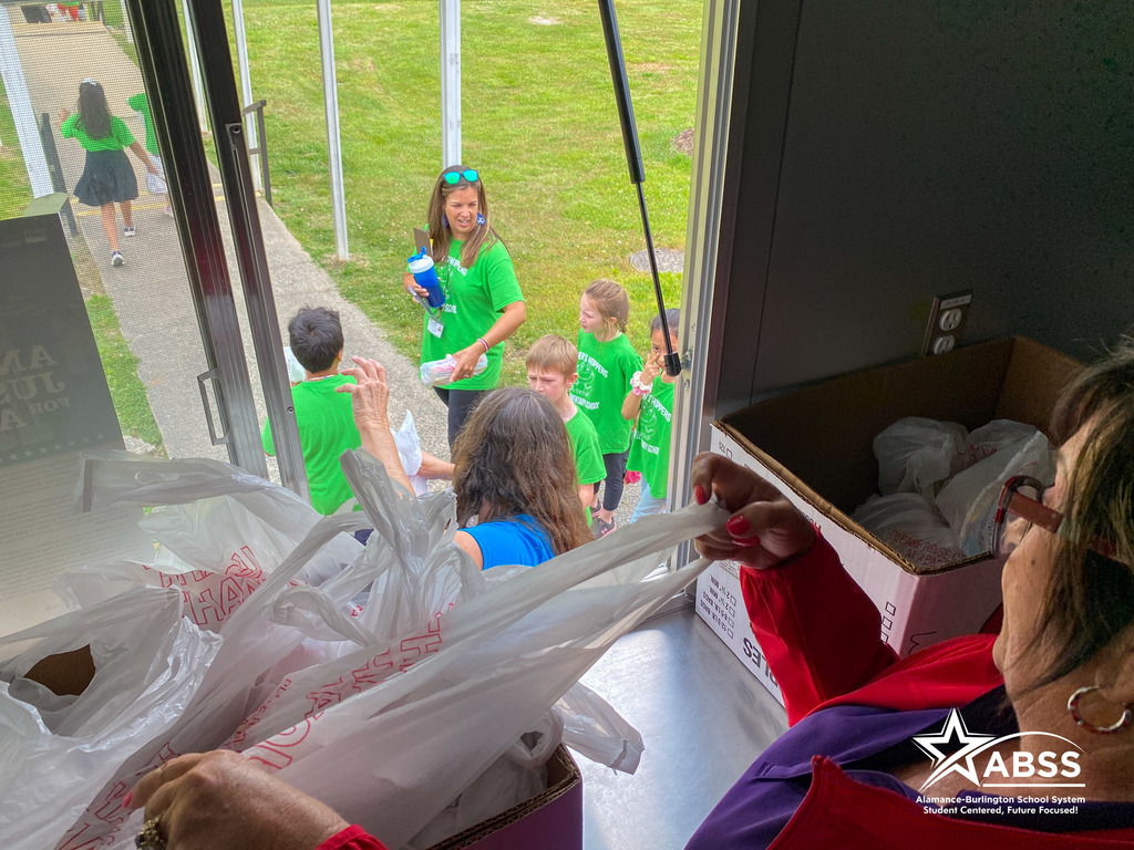 Photograph taken from inside the ABSS MAC'S Diner food truck as students are served bagged lunches