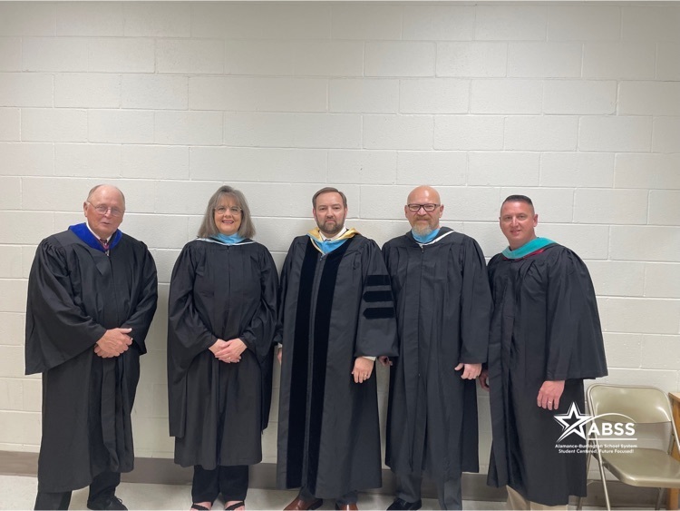 superintendent, Dr. Dain Butler and Board Members in traditional graduation regalia