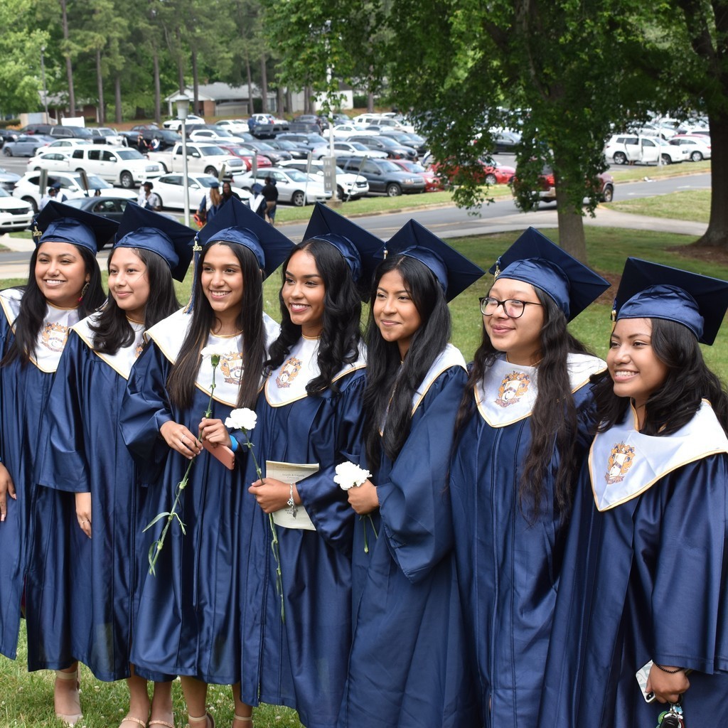 Seniors at Cummings High School wearing their cap and gowns outside, side by side