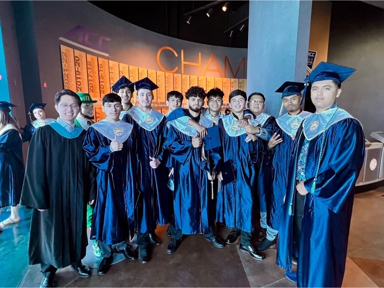 Group of graduates posing before graduation in traditional cap and gown