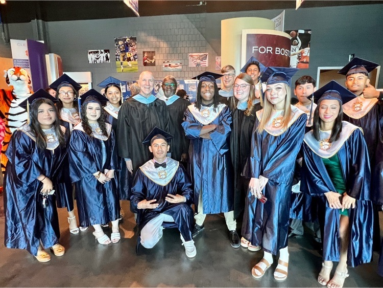 Group of graduates posing before graduation in traditional, cap and gown