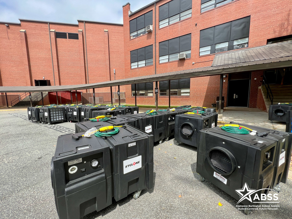 Large Syclone air blowers sit outside a school campus