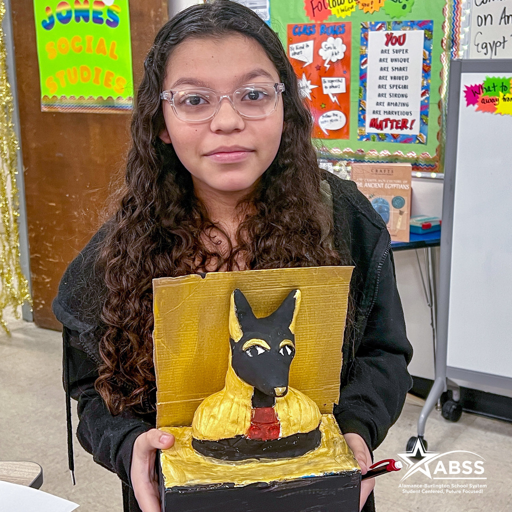 A Broadview Middle School student holds up a model Anubis head made from cardboard