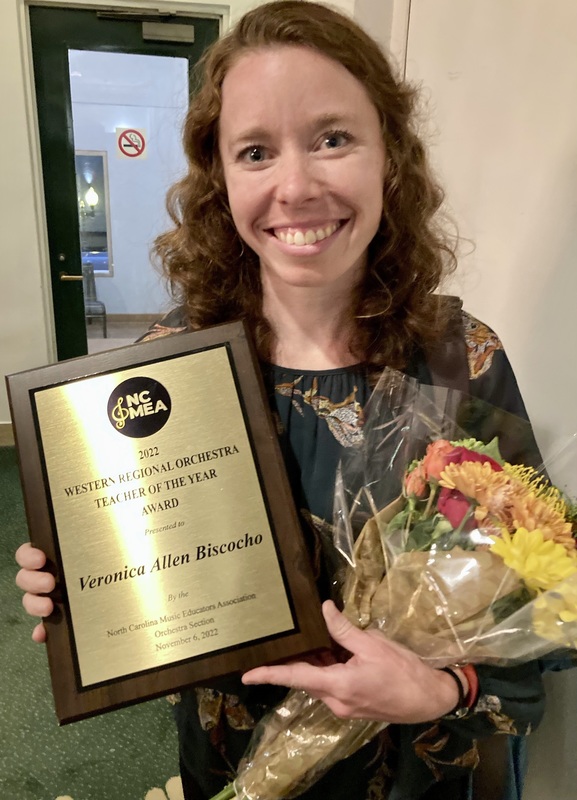 Walter Williams High School Orchestra instructor Veronica Biscocho with flowers and plaque