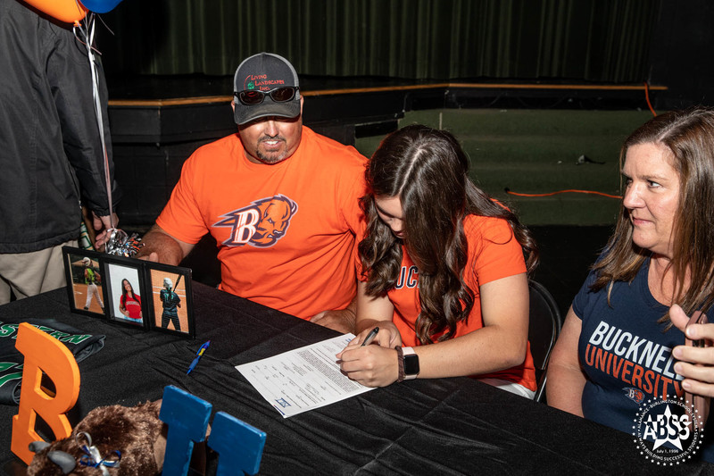 Molly Lawson - Bucknell University - Softball signing letter of intent with parents watching 