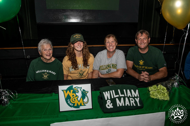 Molly Widderich - William & Mary - Soccer with her family seated at a table with William and Mary banner