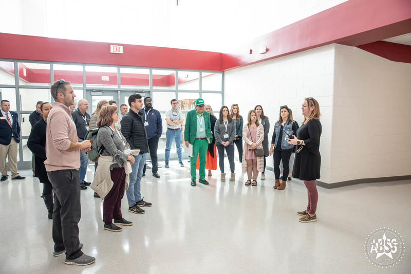 Assistant Principal greeting Leadership Alamance group in hallway at Southern High School's newly constructed front entrance.