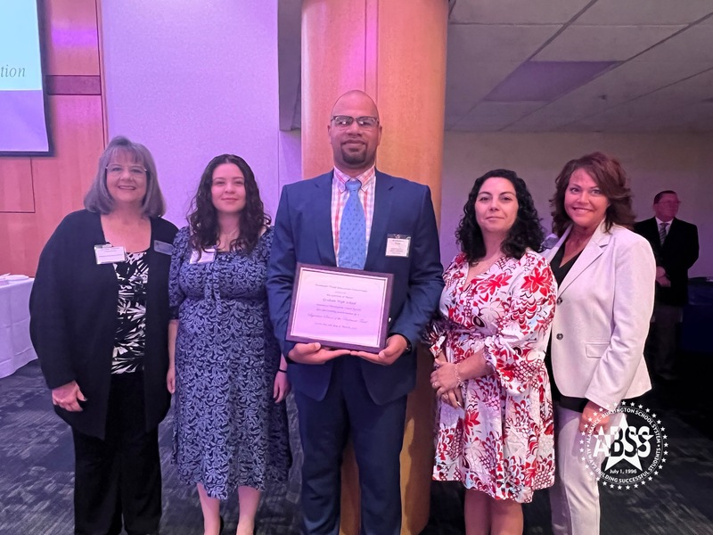 Graham High School team holding plaque posing for photo with Board of Education Chair Sandy Ellington-Graves and Board Member Donna Westbrooks