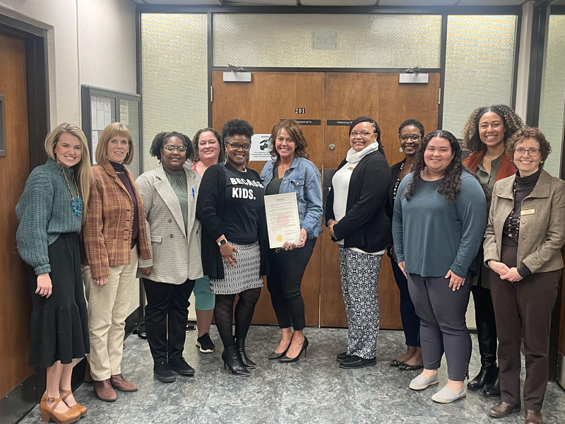Group photograph of Pre-K teachers and leaders and ABSS Board of Education Chair Sandy Ellington-Graves holding a proclamation