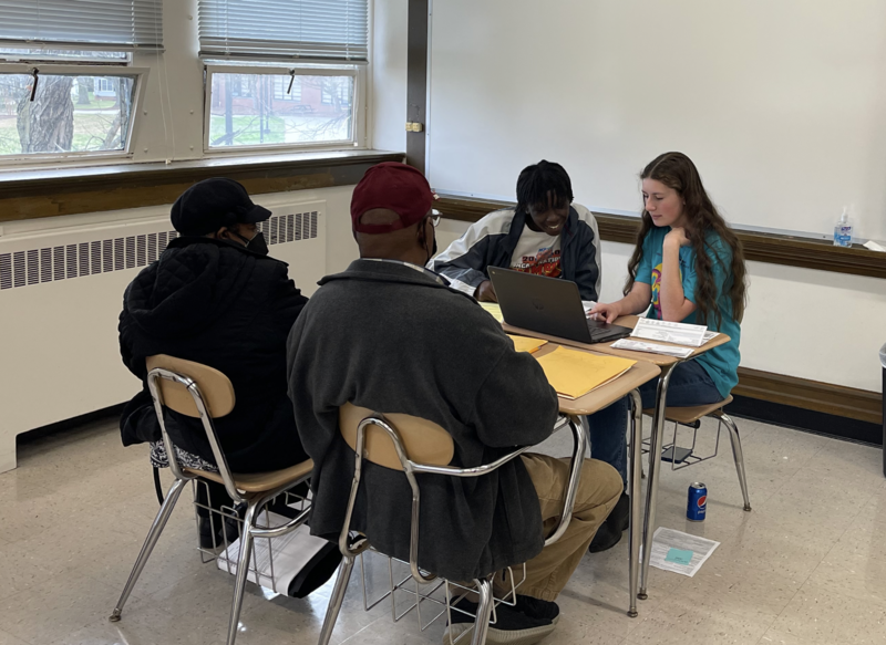 Accounting students helping older couple with taxes. 