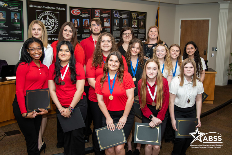 Photograph of a large group of Southern Alamance High School's FCCLA Club standing at the front of a board meeting in three rows holding certificates of recognition