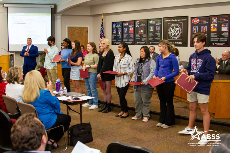 Photograph of nine high school students standing at the front of the Board Meeting auditorium being recognized for their acceptance into the Governor's School program.