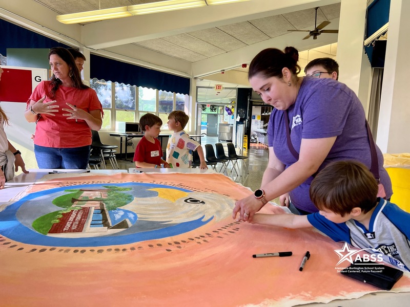 Mother and son putting thumbprint on giant mural