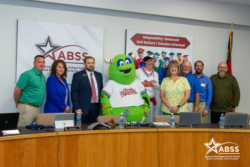 The ABSS Board of Education members standing around Sock Puppet mascots Socksquatch and Whiff