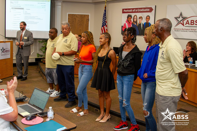 The Cummings High School girls track team and coaches being recognized at the front of the board room