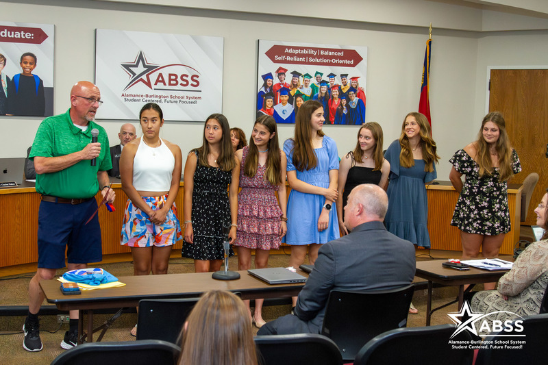 The Eastern Alamance High School girls soccer team and coach being recognized at the front of the board room