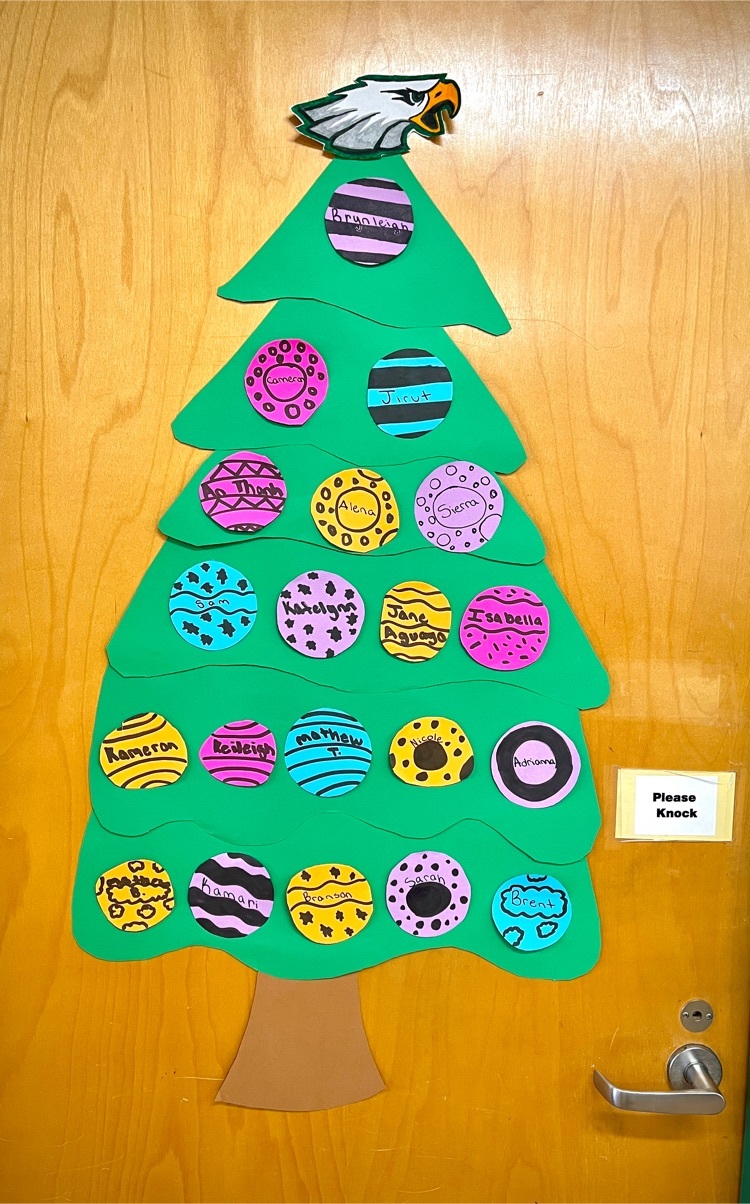 Green paper tree with multi-colored paper ornaments each containing the name of a student